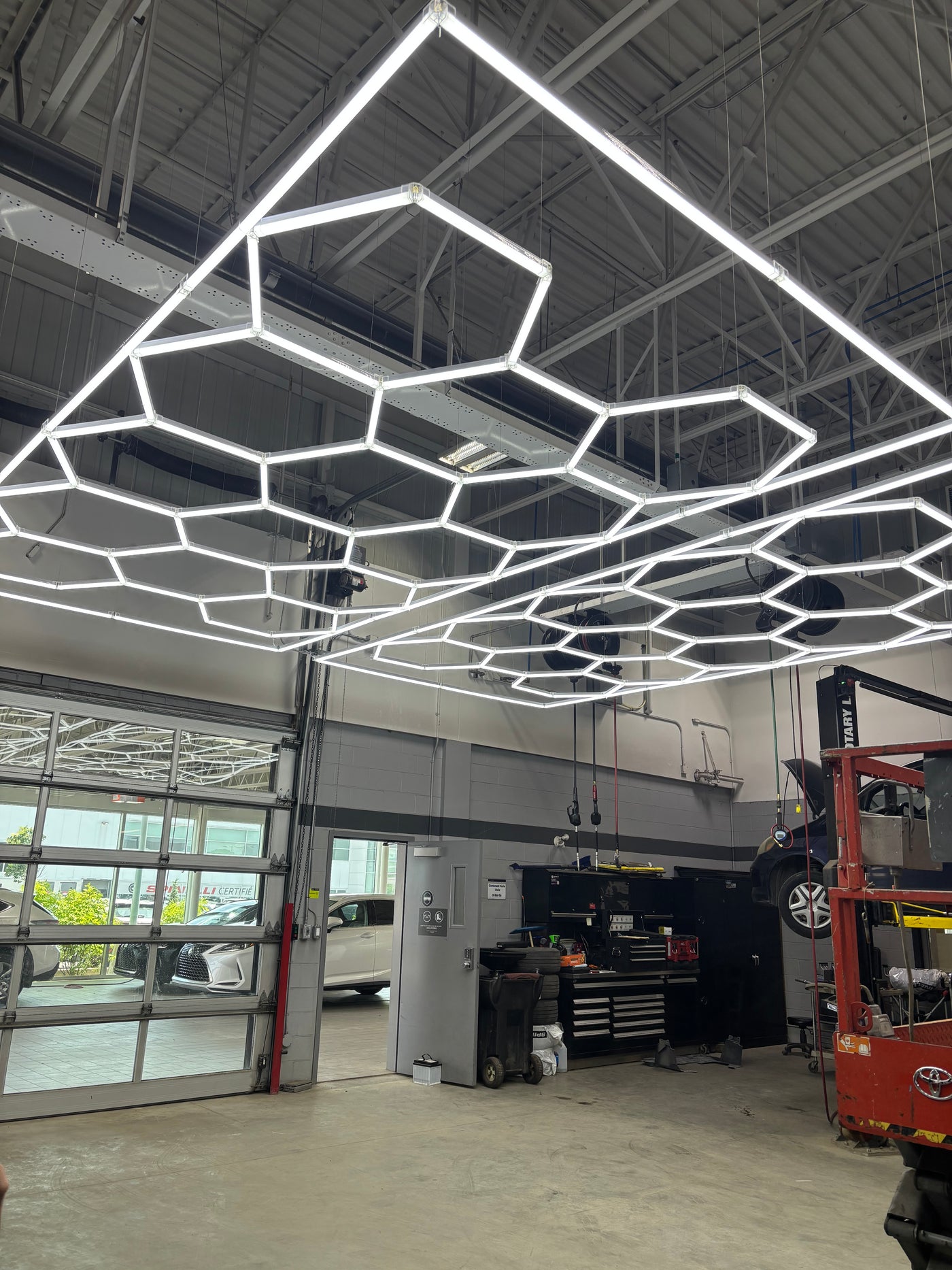 Hexagonal LED installation across an industrial workshop ceiling