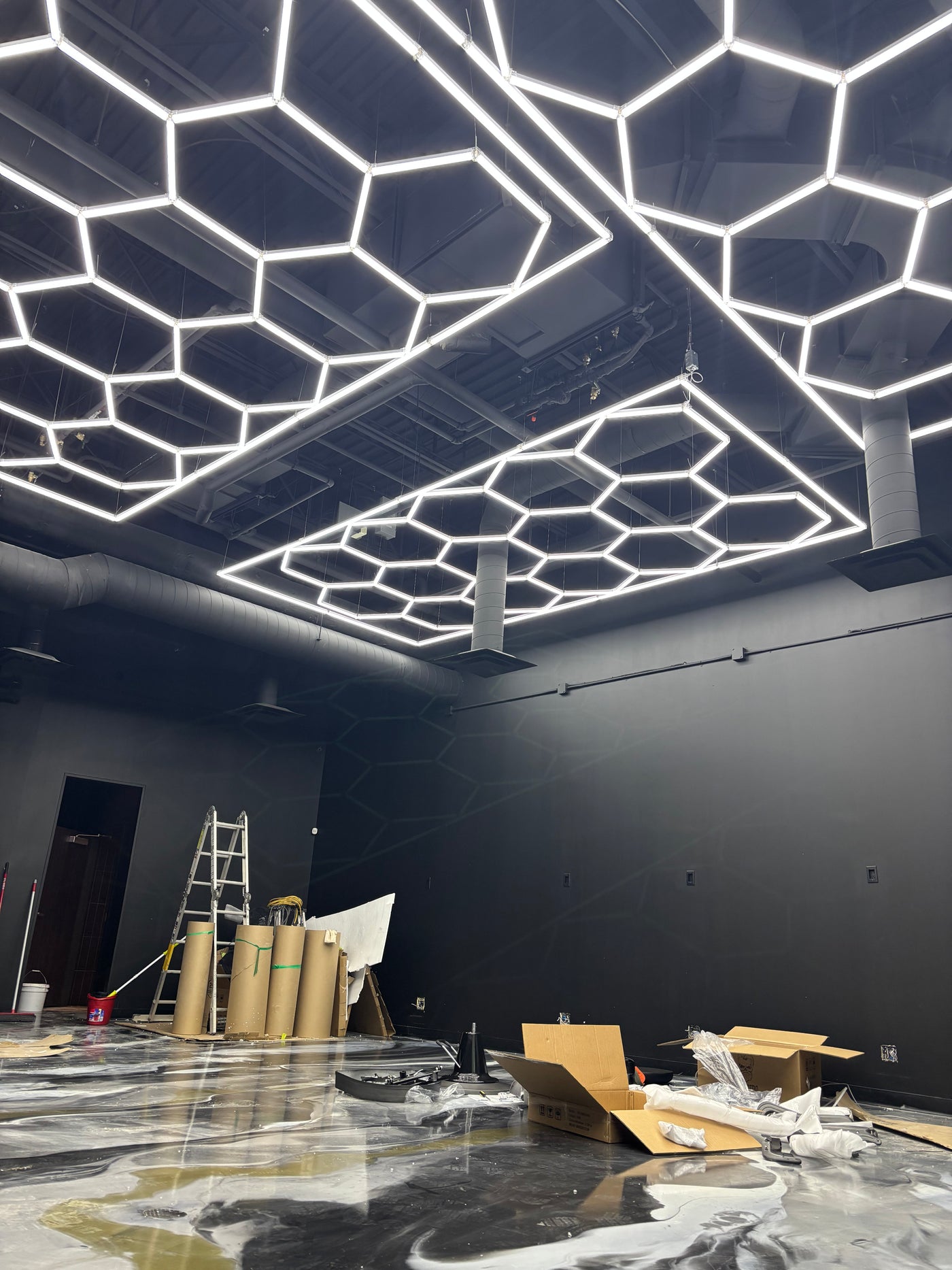 Honeycomb LED system installed on a dark workshop ceiling