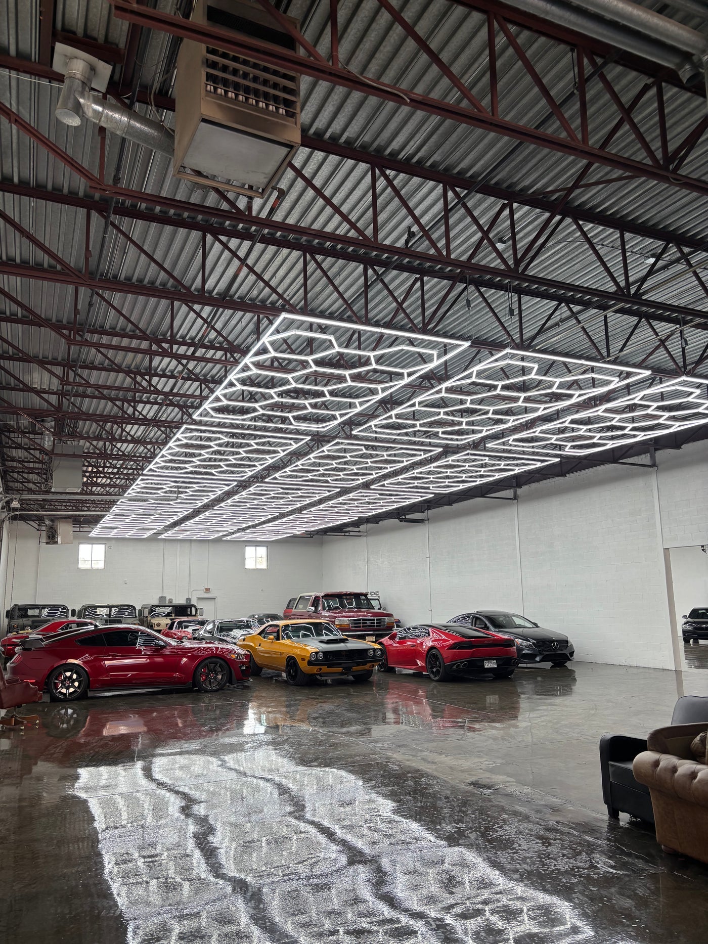 Hexagonal LED lighting installed above vehicles in a commercial garage
